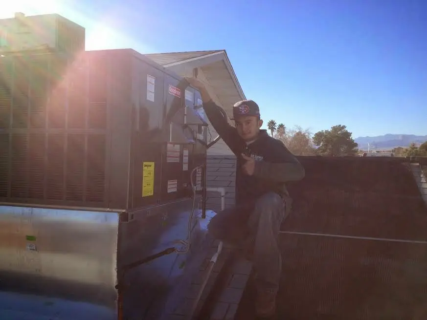 HVAC technician performing AC Tune-Up on a rooftop unit in Mount Pleasant